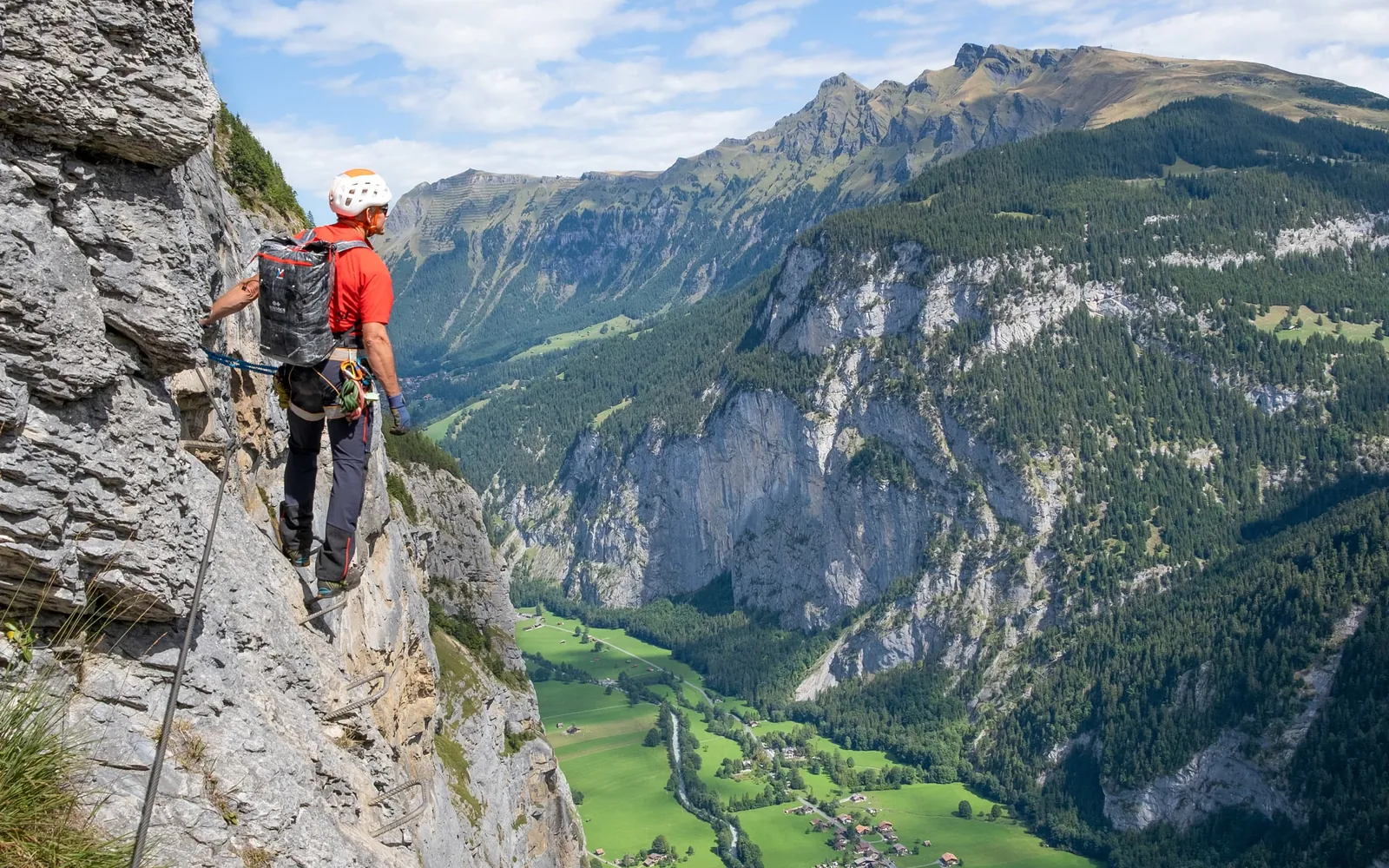 Escalador en la vía ferrata de Mürren, muy por encima del verde valle de Lauterbrunnen